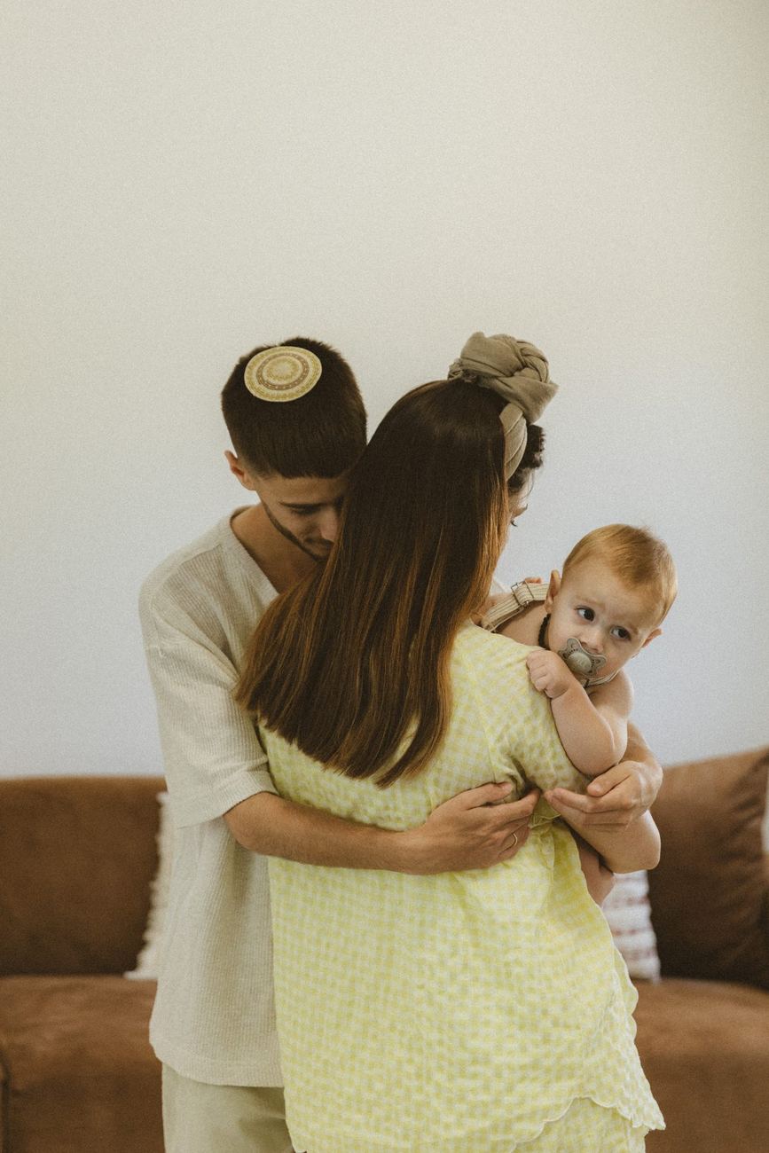 הורים מתחבקים עם התינוק בסלון